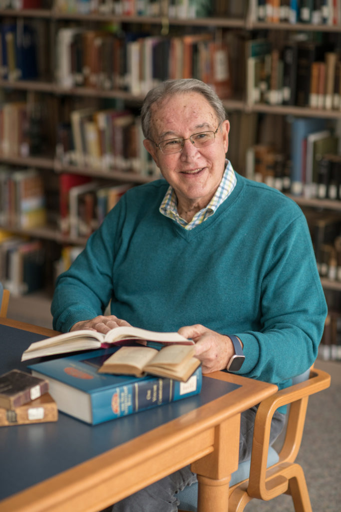 Senior male in library with book